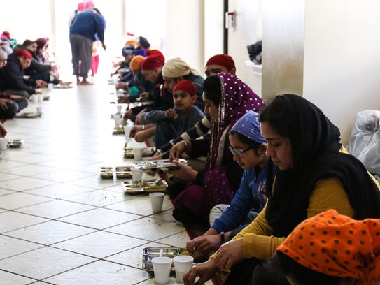 People gather to eat after service at Langar, a Sikh