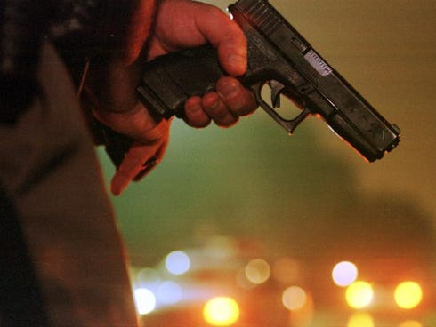   A law enforcement officer holds a 9mm Glock pistol at the ready during a burglary call.  