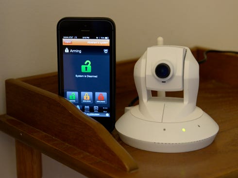 A mobile app and a pan-and-tilt security camera are parts of an Alarm.com home system.