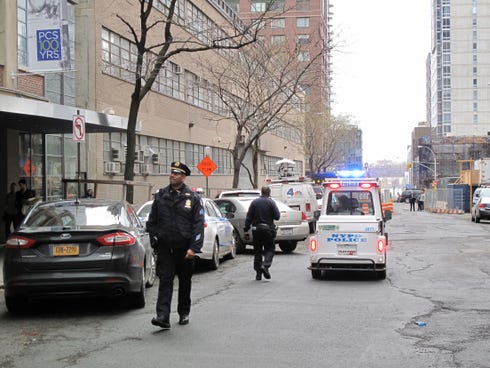 New York Police Department officers walk in front of a high-rise apartment building where they said a 35-year-old man and a 3-year-old child died after plummeting from the building in New York on Dec. 22, 2013.