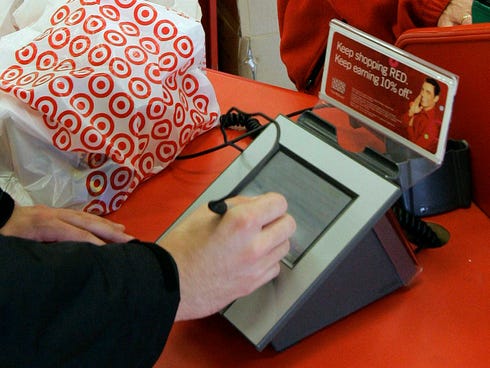 A customer signs his credit card receipt at a Target store.