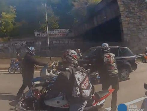 A pack of motorcyclists follow and harass an SUV driving through Manhattan Sunday before smashing in the SUV's window.