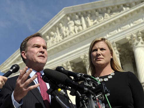 Michigan Attorney General Bill Schuette, left, standing with Jennifer Gratz, chief executive officer of XIV Foundation, speaks to reporters after arguing their case before the Supreme Court on Oct. 15, 2013.