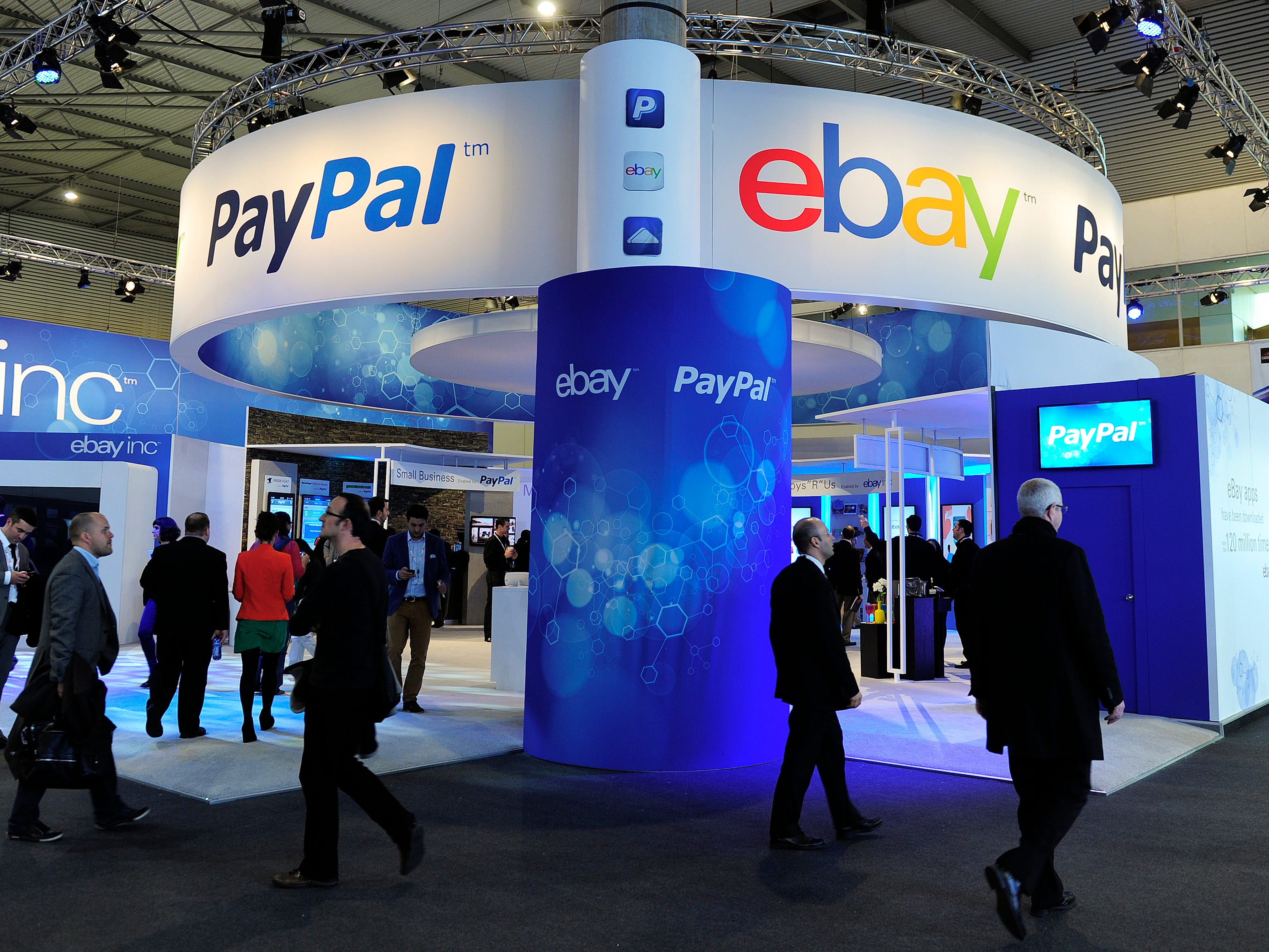 Visitors walk past an eBay and PayPal stand at the 2013 Mobile World Congress in Barcelona in 2013.