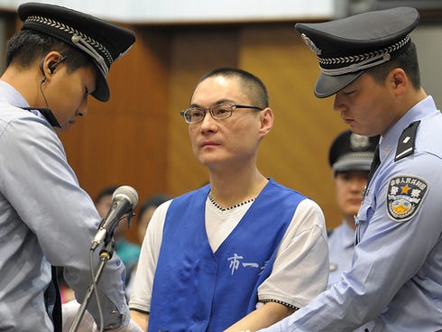 Han Lei is handcuffed by police officers after his verdict was read in a court in Beijing, China.