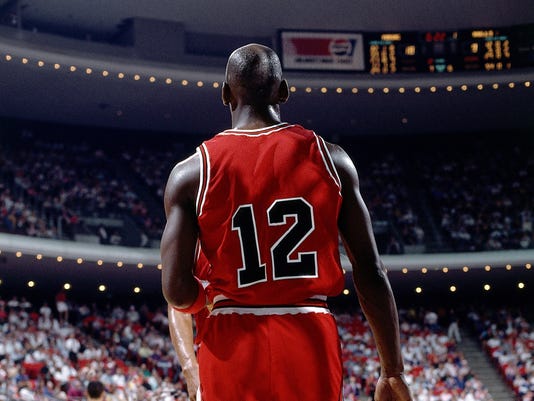 Michael Jordan in the black uniform with red pinstripes introduced