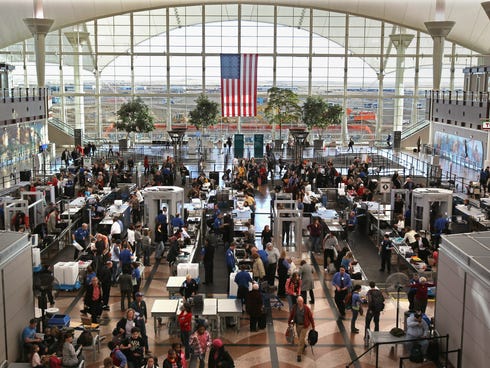 Passengers move through a main security checkpoint at the Denver International Airport. The airport is banning marijuana possession even though it is now legal in Colorado.