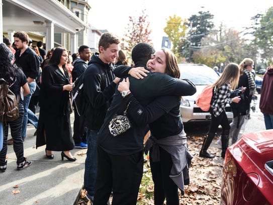 Students embrace at the end of a march against hate