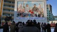 North Koreans gather in front of a portrait of their