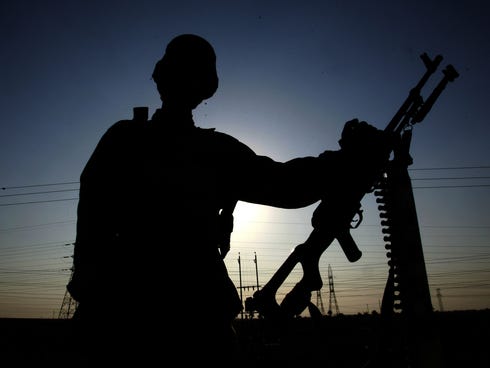 An Iraqi soldier is seen in silhouette as he guards the main check point of Fallujah in January 2005.