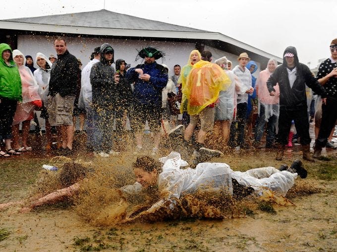 Fans slide through the mud in the infield