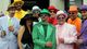 A group of fans in colorful hats and suits are seen in the paddock before the third race of the day at Churchill Downs