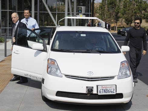 From left, California Gov. Edmund G Brown Jr., state Senator Alex Padilla and Google co-founder Sergey Brin stand by a driverless car they arrived in at Google headquarters in Mountain View, Calif.