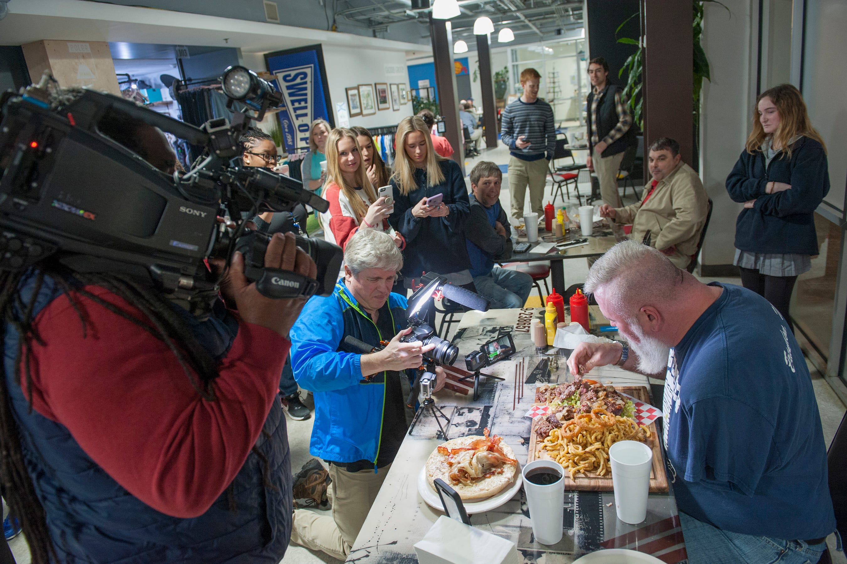 a crowd gathers to witness big eater mike, tackled a 6-pound, 8