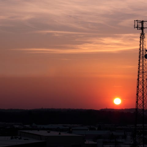 The silhouette of a cell phone tower shot against 