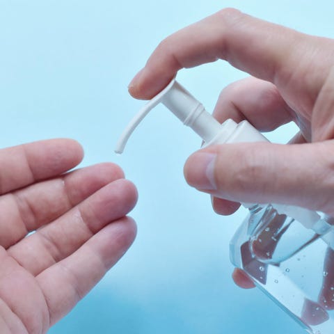 A person squirting some hand sanitizer onto their 