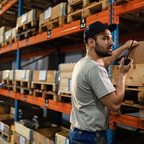 A warehouse worker pulls an item from a shelf.