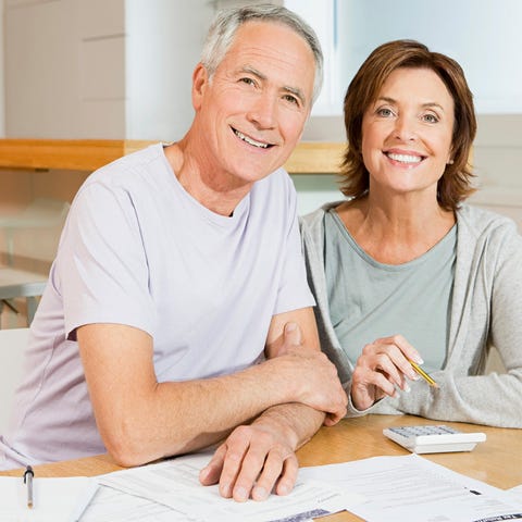 Smiling older man and woman at table with document