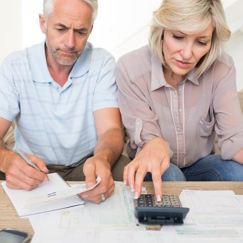 Older couple looking at financial paperwork with c