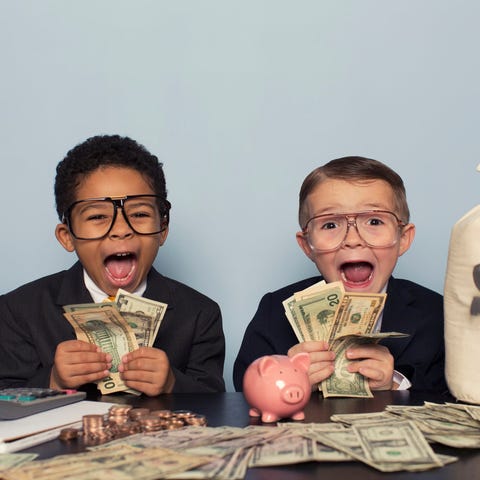 Children dressed in suits make faces while holding