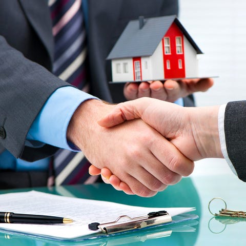 Two businesspeople shaking hands, with one holding