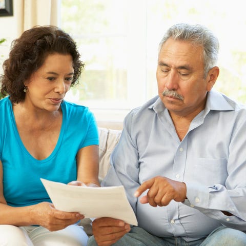 Senior couple pointing at document