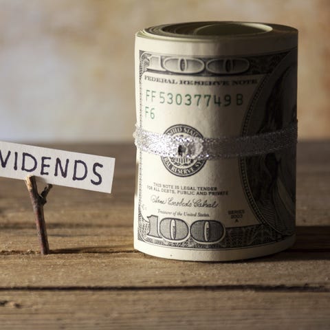 A sign saying dividends, next to a roll of cash.