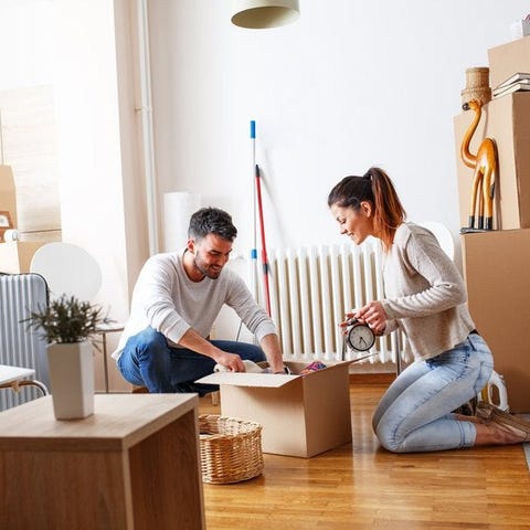 A young couple packing moving boxes in an apartmen