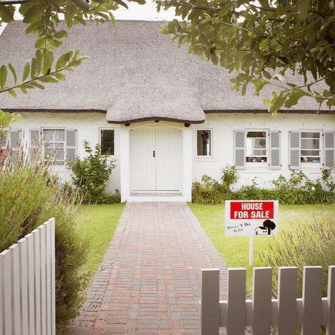 The front of a house with a for sale sign in the l