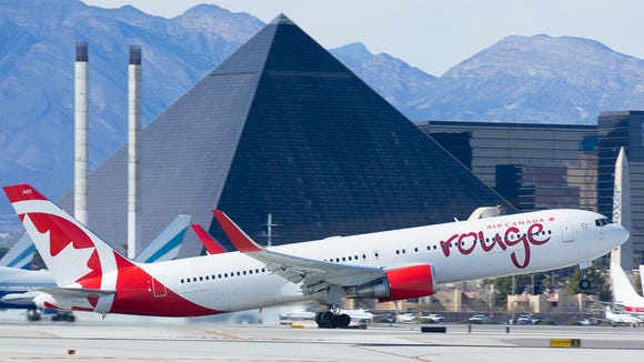 A red Boeing 767 leaves the hot climate of Las Vegas,