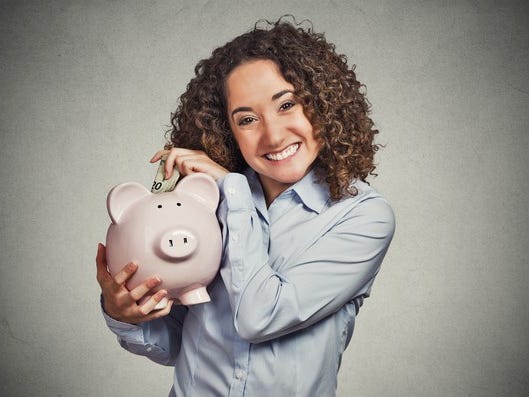 Lady smiling and holding piggy bank