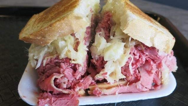 The local Bread Basket Deli chain sells some 20,000 pounds of corned beef every week in sandwiches like this Reuben, piled with warm sauerkraut and melted Swiss cheese on grilled rye.