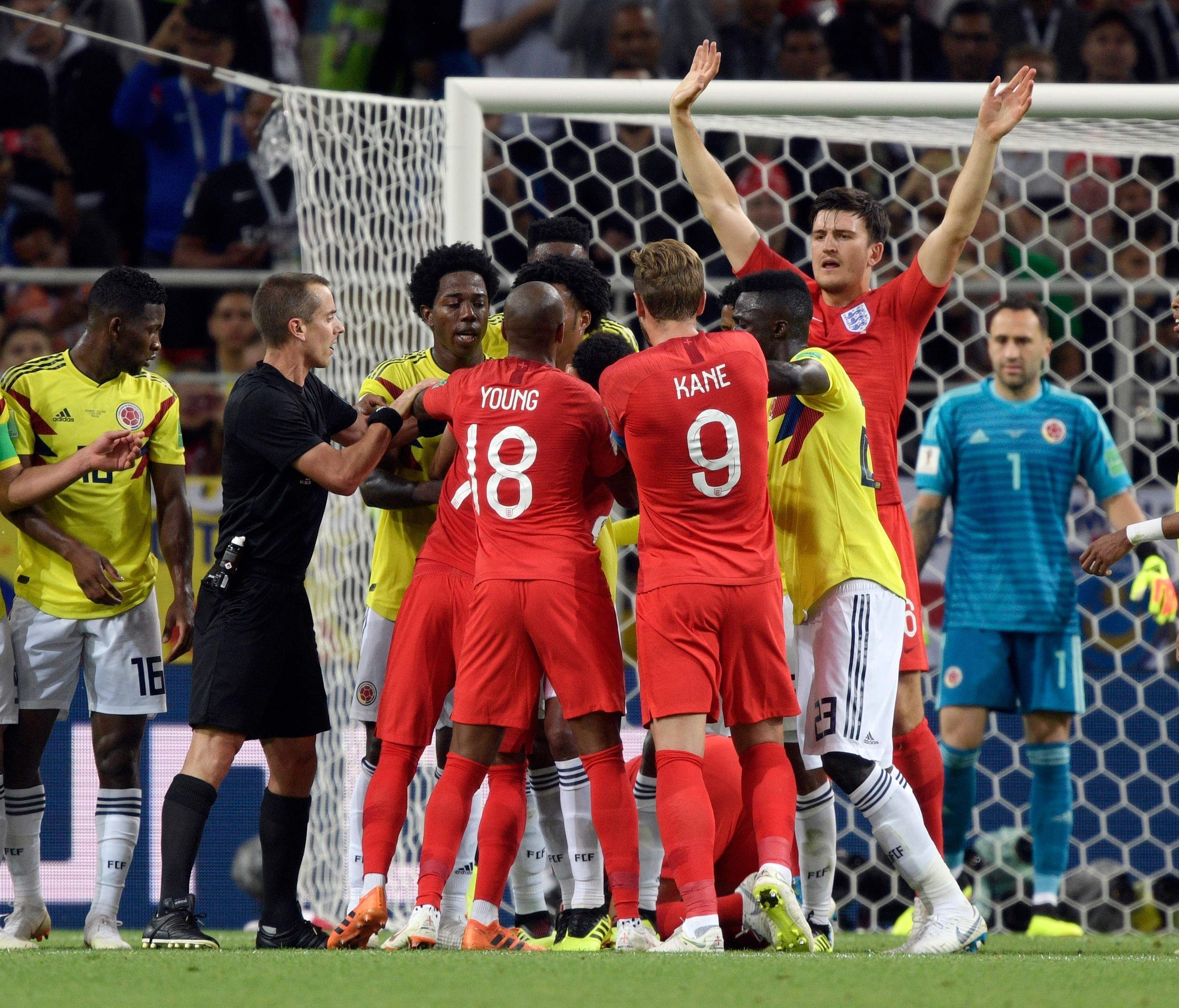 English and Colombian players quarrel as U.S. referee Mark Geiger tries to mediate during their World Cup match.