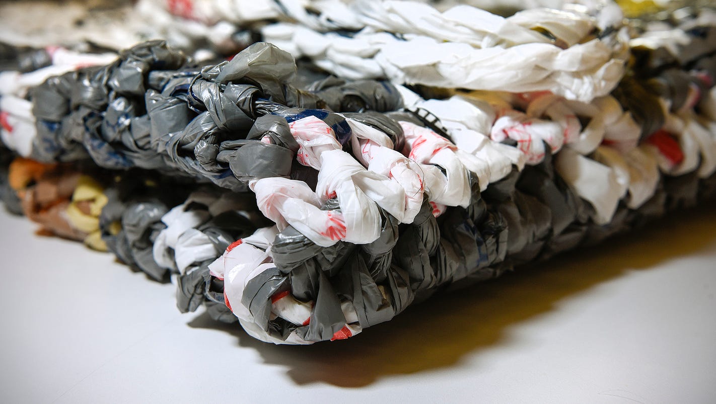 Groups weave plastic bags into mats for homeless people