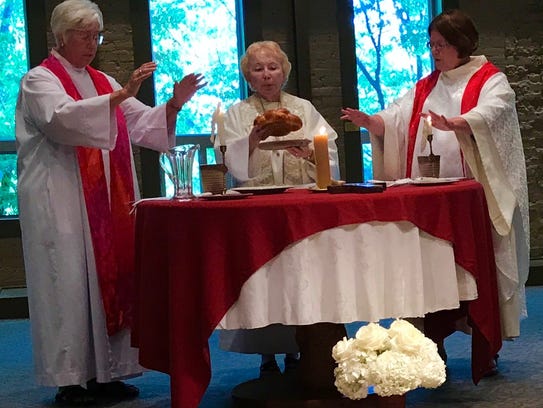 Abigail Eltzroth, right, prepares to celebrate communion