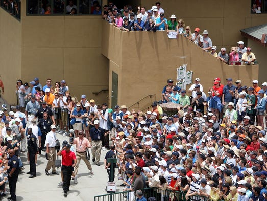 Tiger Woods walks to the first tee during the final