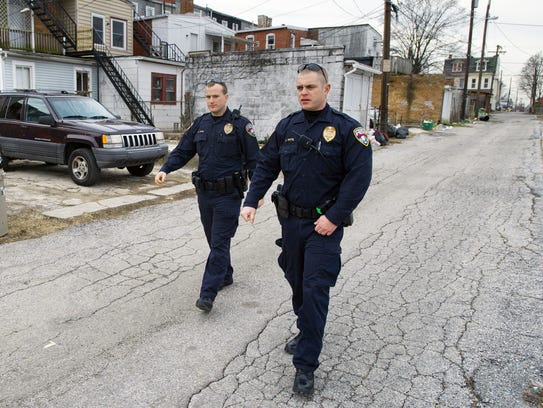 York City Police Officers Matthew Irvin (left) and Kyle Pitts walk an alley behind West Princess Street in York in 2012. Pitts was injured in a shooting in Harrisburg on Thursday.