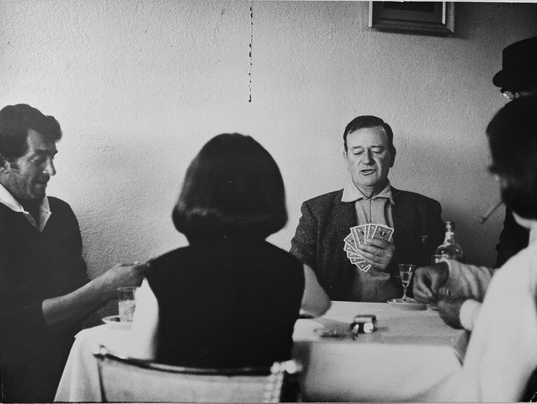 John Wayne and wife Pilar playing cards with Dean Martin one evening during filming of 'The Sons of Katie Elder.'