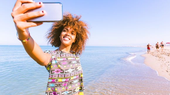 A young woman takes a selfie.