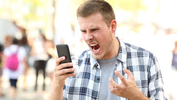 Angry man screaming at his phone.