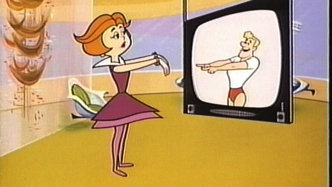 Jane Jetson Works Out With A Virtual Instructor On A Flat Panel Tv 