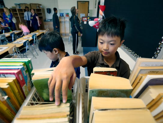 Loic Yu, 9, looks through the classroom books next