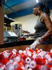 Sharon Hill, Red Bank, fills containers of gun oil