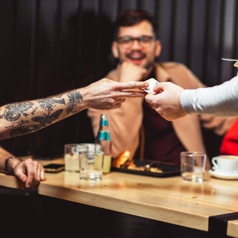 A man handing his credit card to a waiter at a res