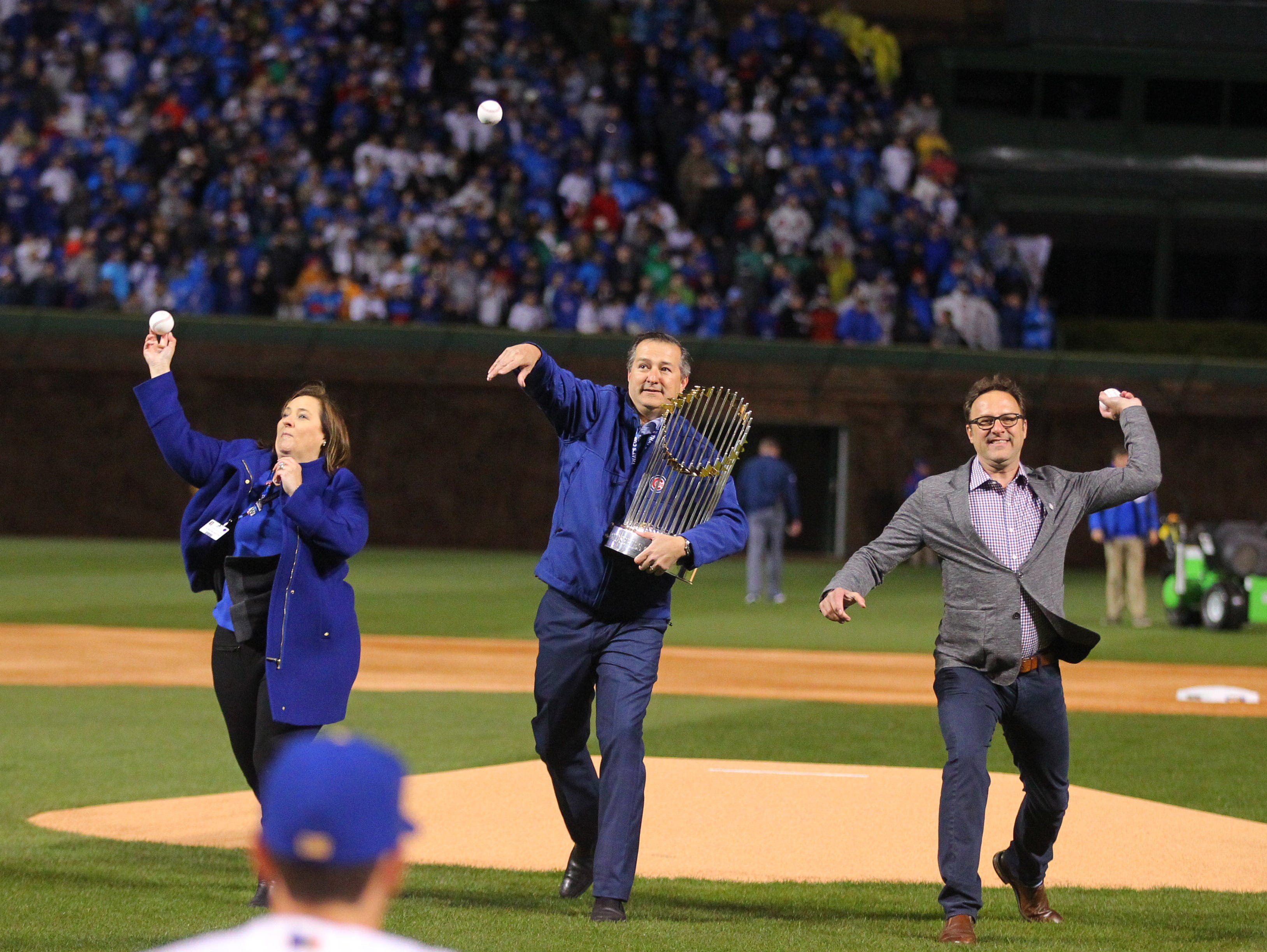 Todd Ricketts, right, throws out the first pitch on opening night at Wrigley Field with siblings Laura and Tom.