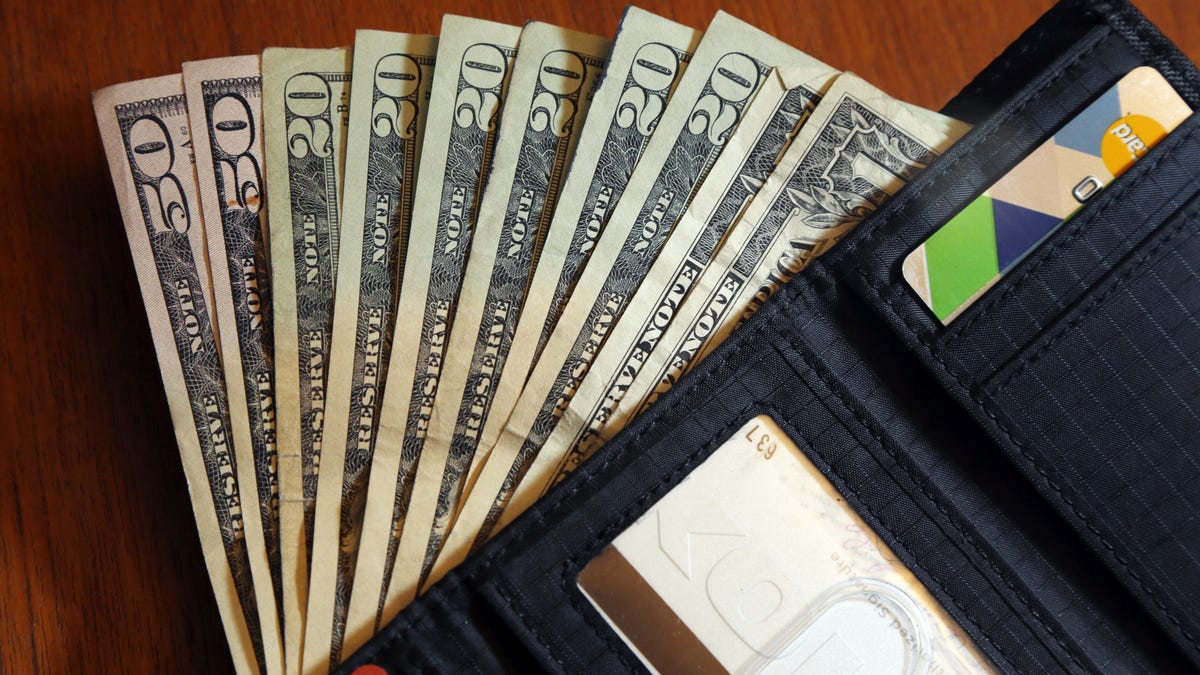 FILE - Cash is fanned out from a wallet in North Andover, Mass., June 15, 2018. The U.S. economy grew faster than expected in the July-September 2022 quarter, the government reported Thursday, Oct. 27, 2022, underscoring that the United States is not in a recession despite distressingly high inflation and interest rate hikes by the Federal Reserve. But the economy is hardly in the clear. (AP Photo/Elise Amendola, File)