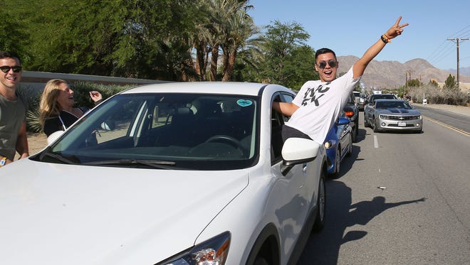 Arman Lim of San Francisco hangs out of his car window while being stuck in slow-moving traffic at Coachella where concertgoers were lined up to get into the camping area a day before the festival begins, April 13, 2017.