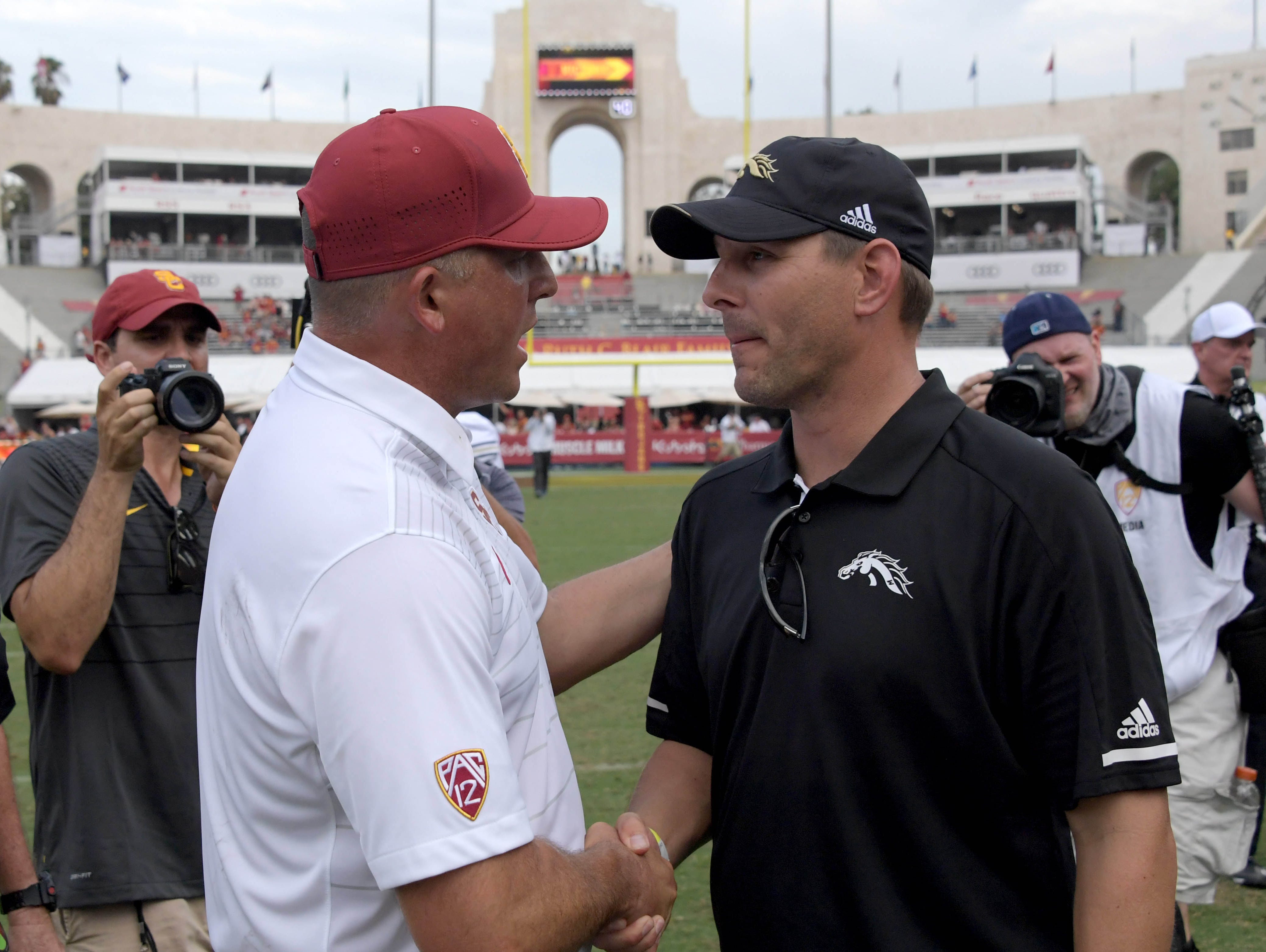 Southern California coach Clay Helton (left) shakes hands with Western Michigan head coach Tim Lester on Saturday after the Trojans managed to hold off the Broncos.