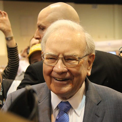 Warren Buffett smiling with several people in the 