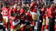 San Francisco 49ers players kneel during the performance